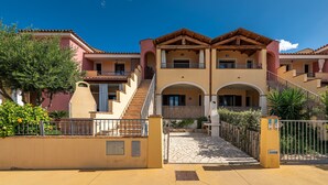 A multi-story hotel with a central courtyard, balconies, and a tiled entrance.