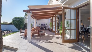 An outdoor patio with a pergola, seating, and a grill area. - Villa 'Scandinavian Design' with Sea View, Wi-Fi and Air Conditioning (Puerto Banús)