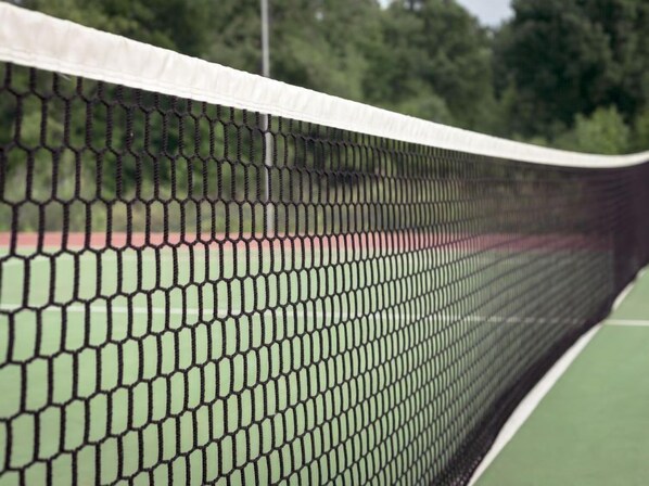 Una cancha de tenis con una red en primer plano.
