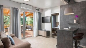 A modern hotel room with a sofa, a dining area, a TV, and a balcony with curtains. - Mobilhome Villa Prestige by Interhome (Rovinj/Bale)