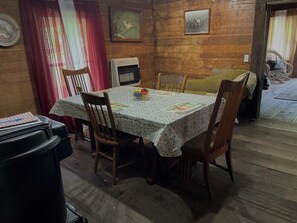 En matplats med ett bord täckt av en duk med blommönster, omgivet av trästolar.