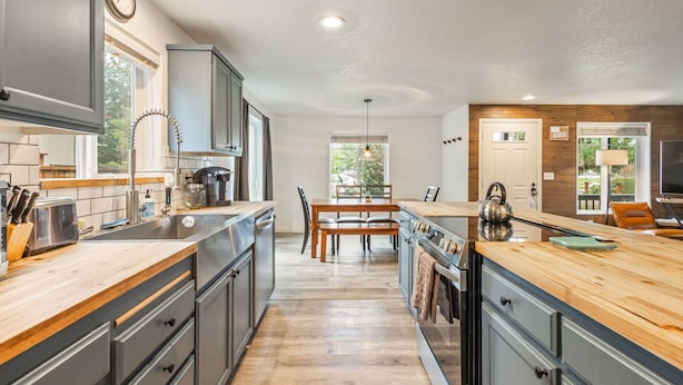 A modern kitchen with a central island, wooden countertops, and built-in appliances. - Walk to Downtown Sisters - DOG Friendly - Updated! (Sisters)