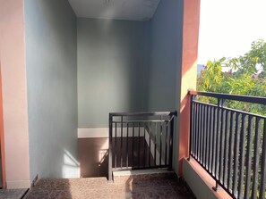 A balcony with a metal railing, a tiled floor, and a light blue wall. - OYO 90111 Almeerah Homestay Syariah (Makassar)