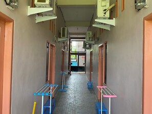 A corridor with multiple doors, air conditioning units, and a tiled floor. - OYO 90111 Almeerah Homestay Syariah (Makassar)