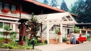 A building with a covered entrance, a statue, and a staircase leading to the main entrance. - Fewo 3E Terr., Kochnische, 1 Schlaf- und 1 Wohn-/schlafzimmer, max 4 Pers (Ruhpolding)