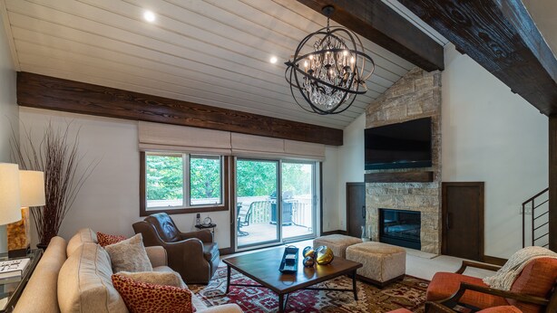 A spacious living room with a fireplace, comfortable seating, and large windows.