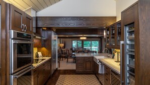 A modern kitchen with dark wood cabinets, stainless steel appliances, and a large island.