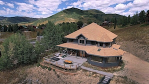 A large house with a spacious deck and a covered outdoor area. - Whetstone Wonder, Views! Pet Friendly, Hot tub (Mt. Crested Butte)
