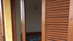 A wooden door leading to a room with a bed and a tiled floor. - Holiday Home Residence "i delfini" (Badesi)