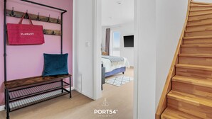 A modern interior with a wooden bench, a red bag, and a staircase. - Wolke 7 - Infrared Sauna, Fireplace, Rooftop Terrace, Bathtub, Parking Space (Olpenitz)