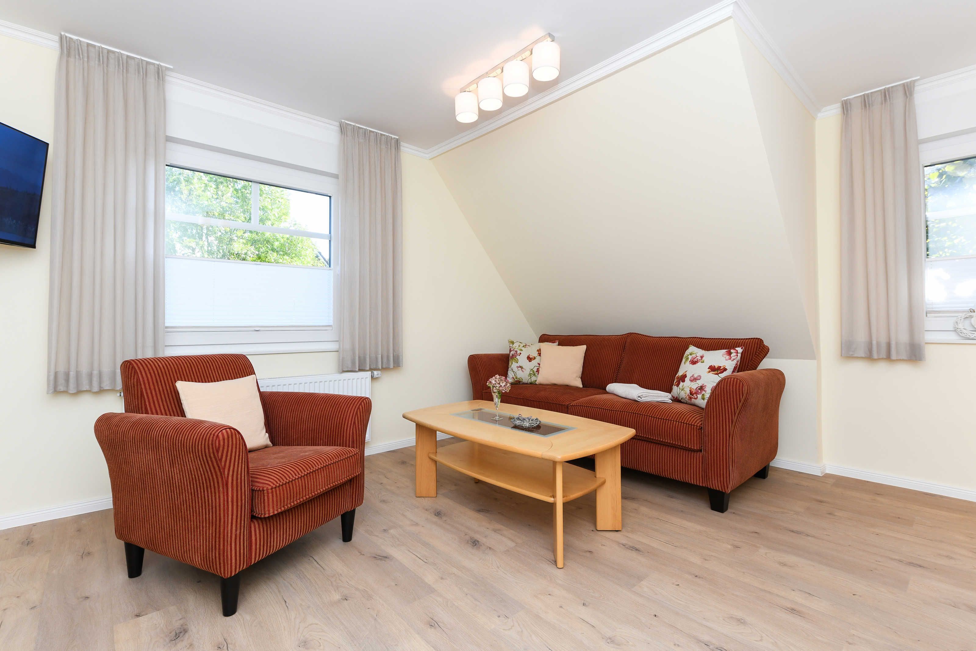 Ein Wohnzimmer mit Sofa, Sessel und Couchtisch.