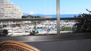 A balcony with a view of a marina and a large hotel building.