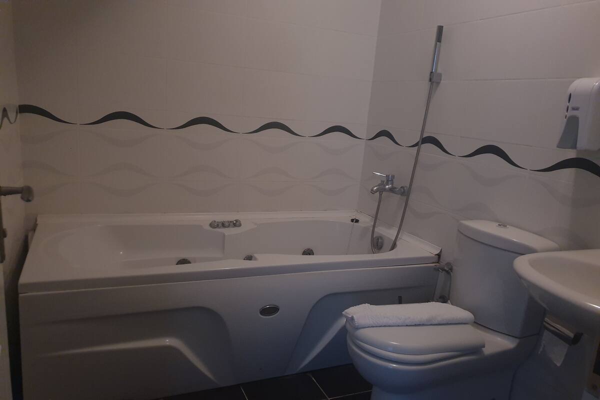 A bathroom with a bathtub, toilet, and a shower.
