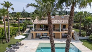 A two-story house with a swimming pool, surrounded by palm trees and a well-maintained lawn. - Villa at the entrance to St Tropez sea view beach 2 minutes walk (Gassin)