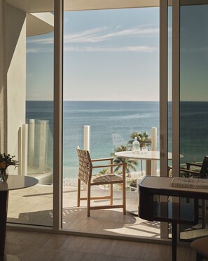 A modern room with a large window overlooking the ocean, a round table with chairs, and a small potted plant. - Four Seasons Hotel and Residences Fort Lauderdale (Fort Lauderdale)