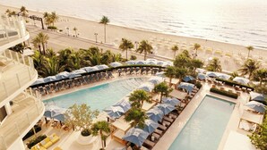 Ein Resort mit Pool, Strand und Palmen.