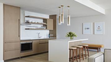 Una cucina moderna con mobili in legno, un'isola centrale con sgabelli, forno integrato e luci a sospensione.
