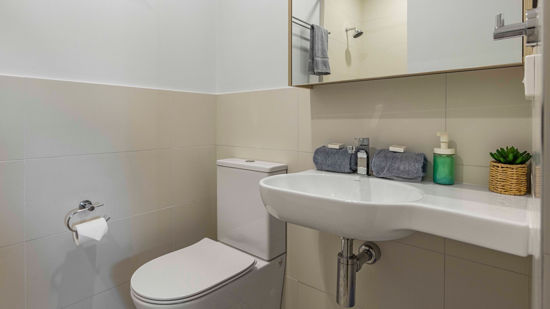 Une salle de bain avec des toilettes, un lavabo et une douche.