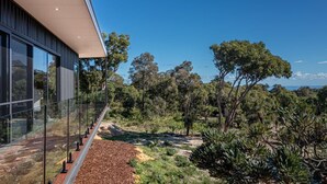A modern building with large windows and a view of a natural landscape. - Carpe Artes – Peaceful Creative Luxury with Ocean Views (Margaret River)