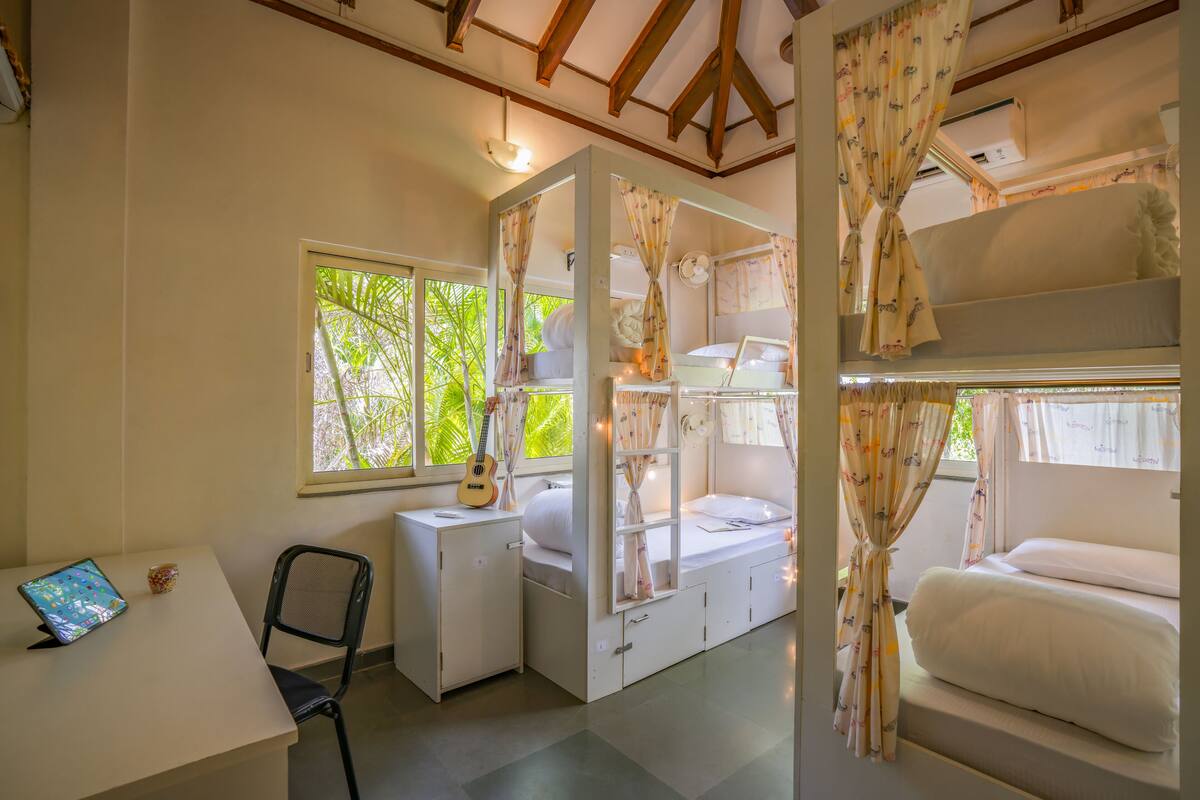 A compact room with bunk beds, a desk, and a chair.