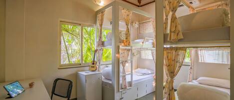 Habitación pequeña con literas, un escritorio y una silla.
