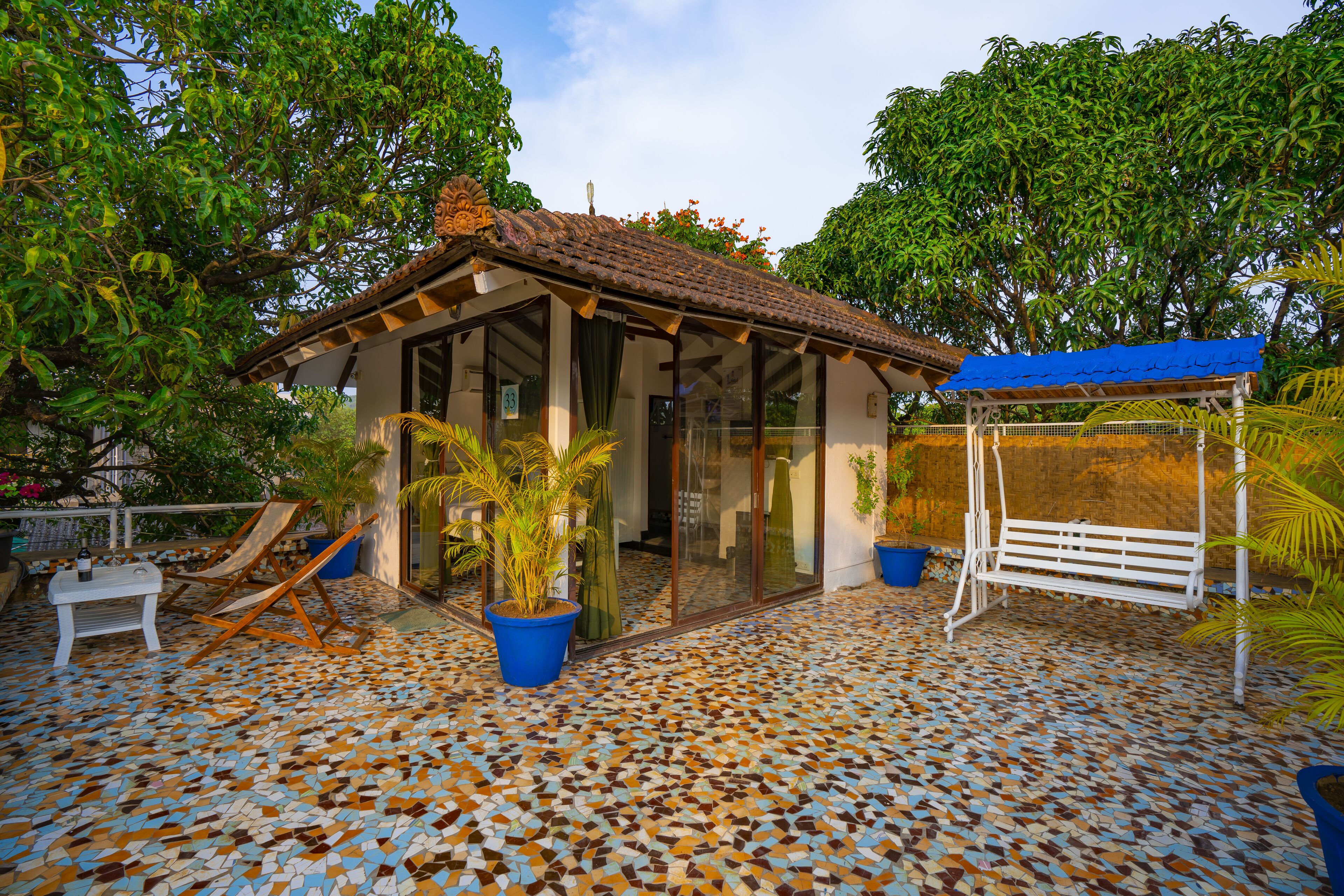 A small building with a tiled roof and a covered seating area.