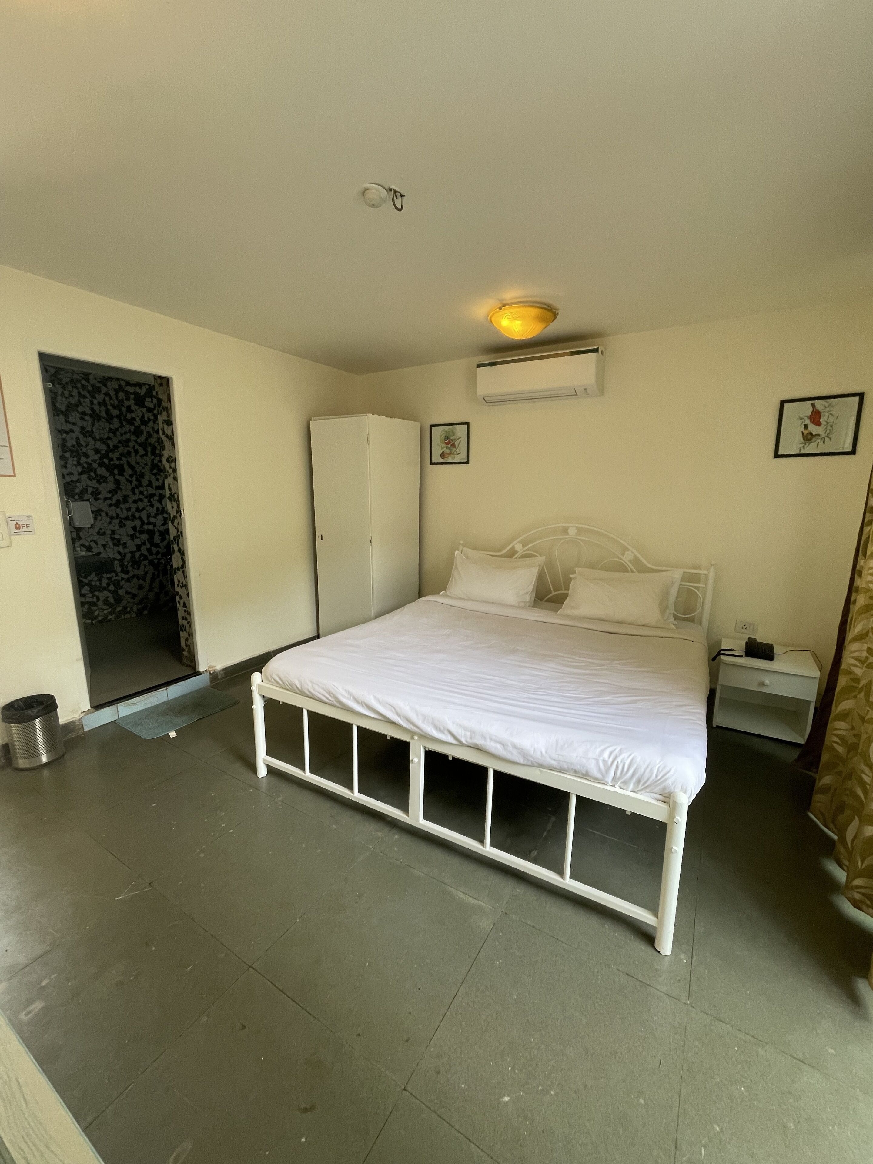 Camera da letto con un letto singolo, un armadio, un comodino e un condizionatore d'aria a parete.