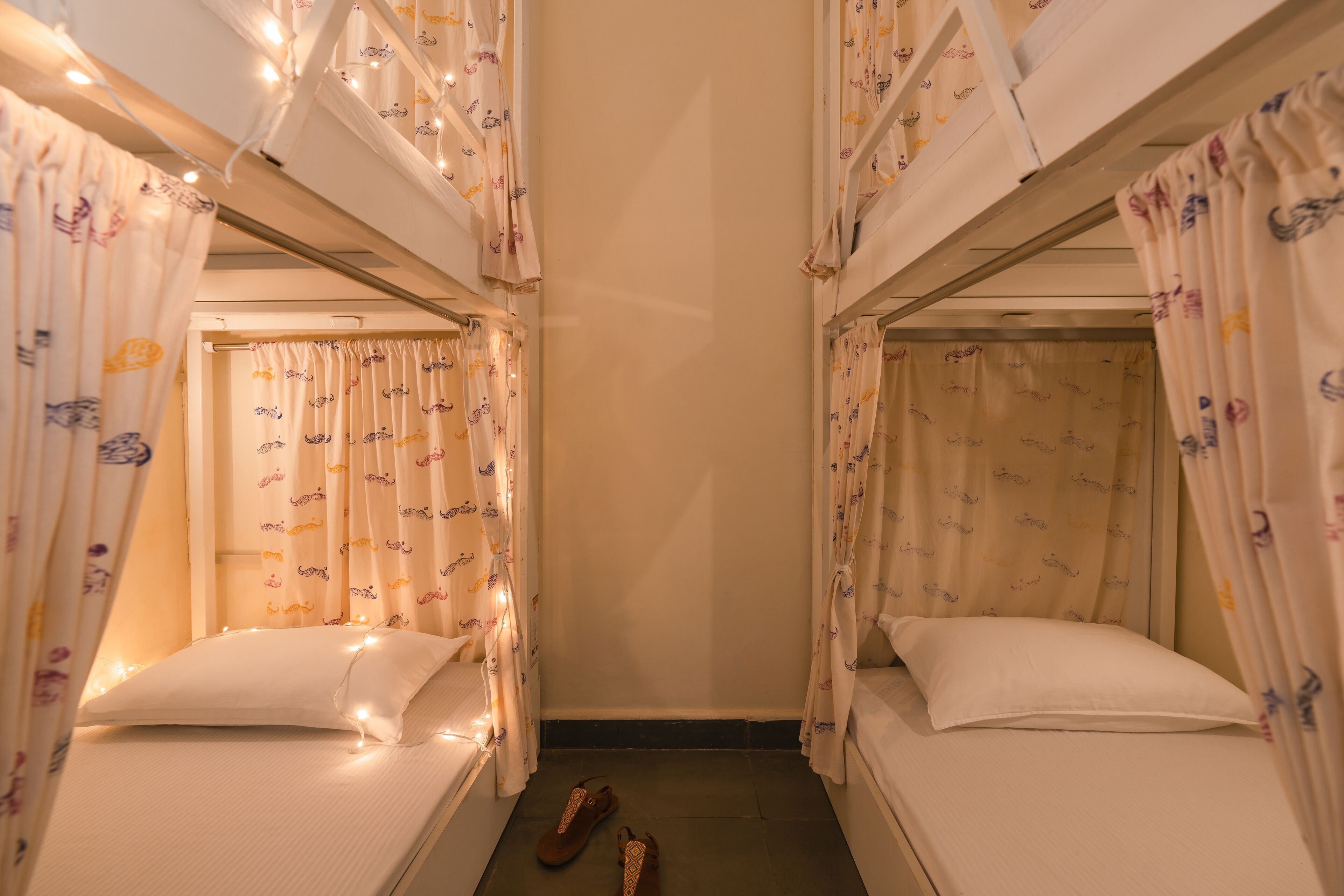 Un dormitorio con literas, cada una con una cortina decorada con un estampado de pequeños animales.