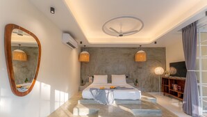 Un dormitorio moderno con una cama grande, un ventilador de techo y un espejo amplio.