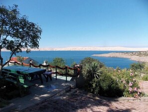 Enjoy a serene lakeside retreat with a picnic table and benches amidst lush vegetation.