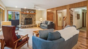 A living room with a stone fireplace, a television, and a sofa. - Experience slope side on Salamander at The Haven! (Canaan Valley)