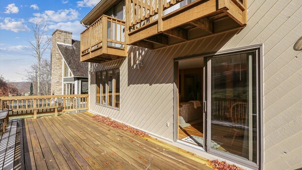 A modern house with a wooden deck, large sliding glass doors, and a stone chimney. - Experience slope side on Salamander at The Haven! (Canaan Valley)