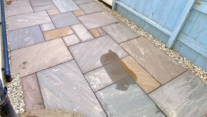 A patio with stone tiles and a blue wooden fence. - Spacious Two Bed Apartment in Poole (Poole)