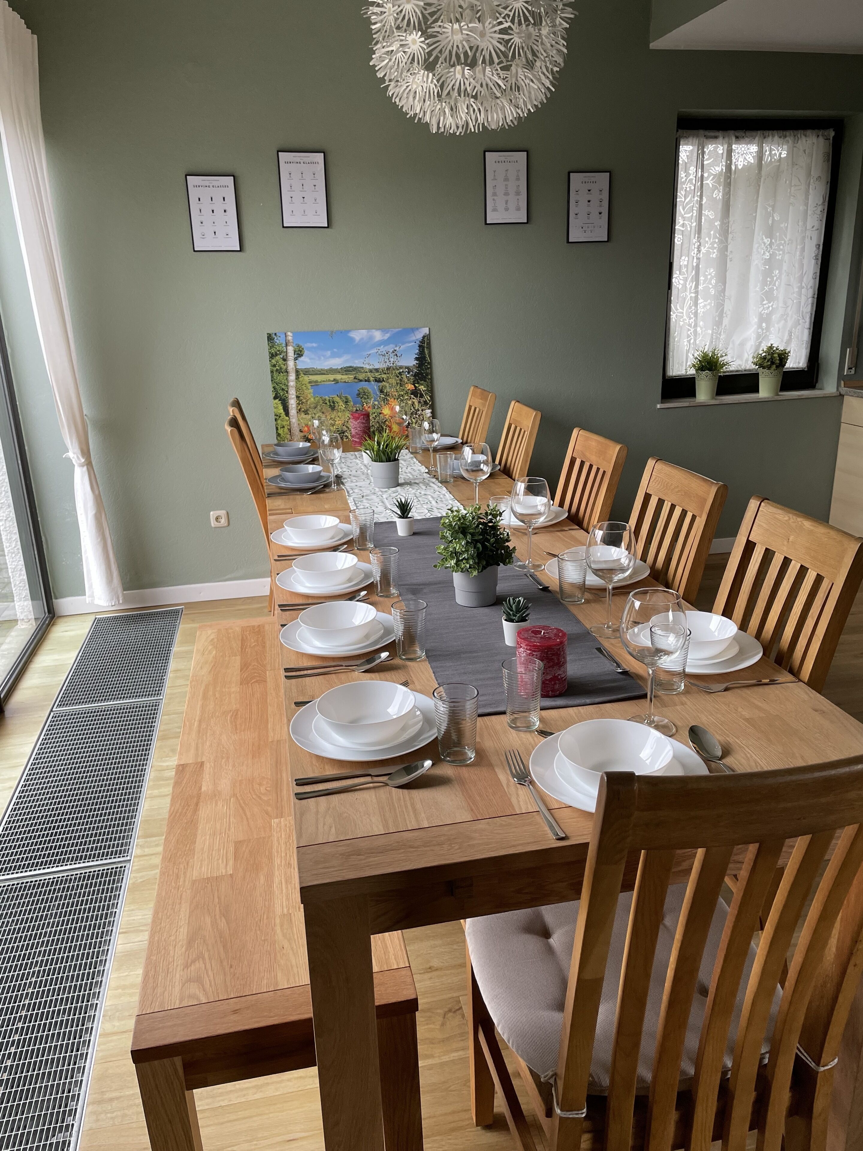 Ein Esszimmer mit einem langen Holztisch, gedeckt für sechs Personen, umgeben von Holzstühlen.