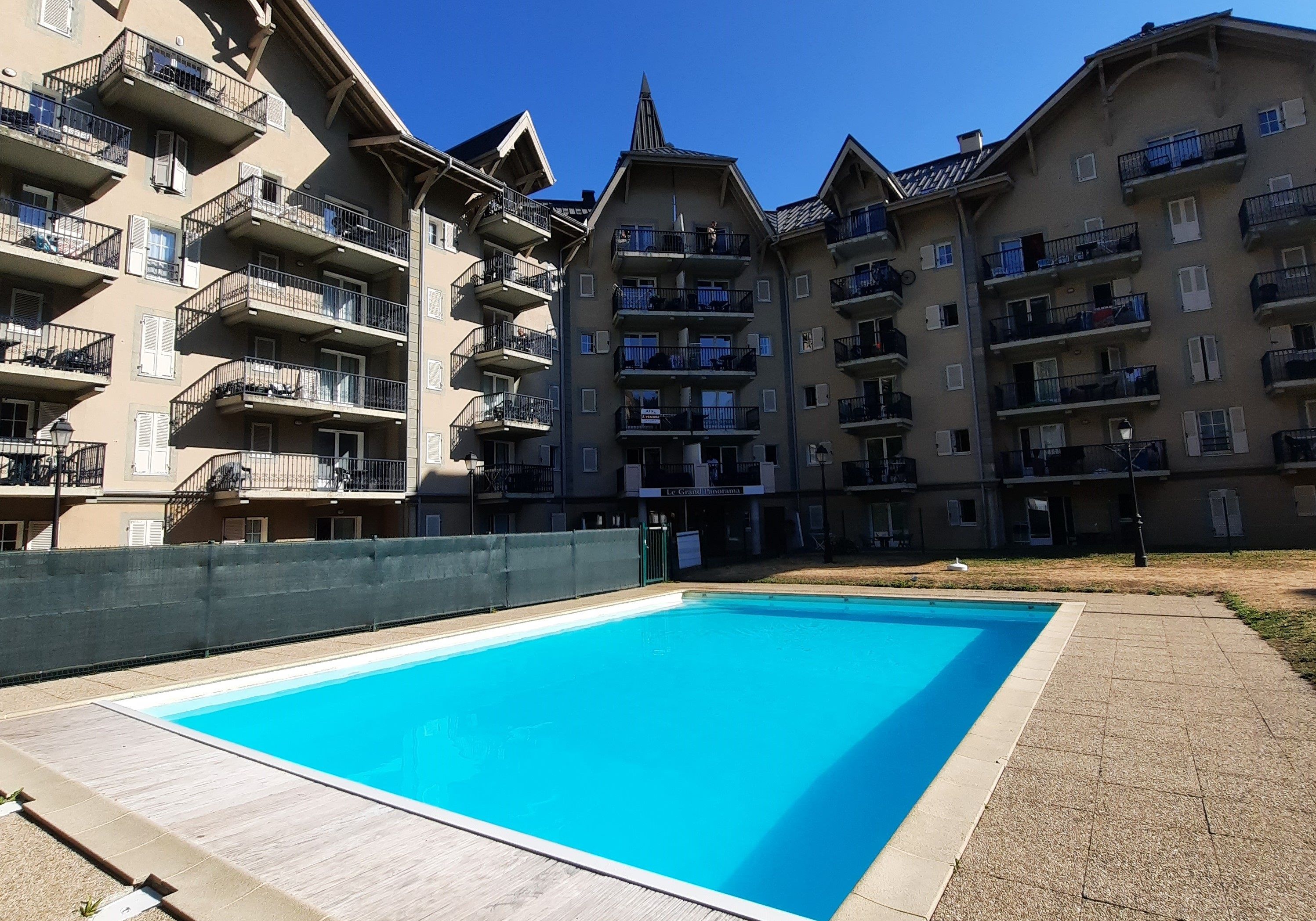 Une piscine entourée d’immeubles résidentiels à plusieurs étages, dotés de balcons.