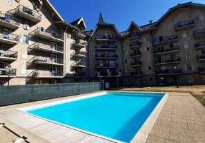 A swimming pool surrounded by multi-story residential buildings with balconies.