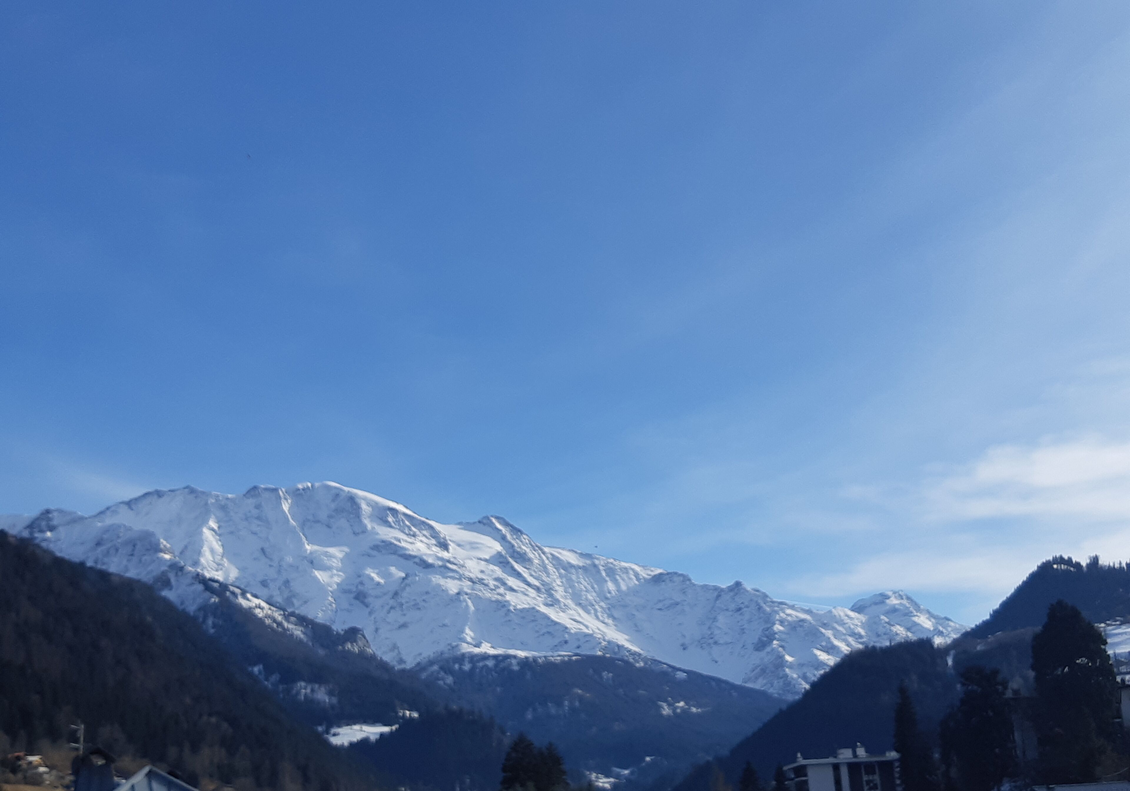 Un paysage de montagne avec des sommets enneigés et un ciel dégagé.