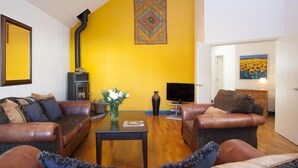 A living room with two leather sofas, a coffee table, and a TV.