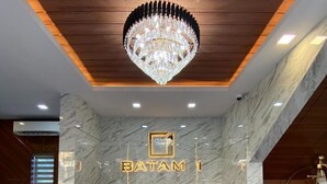 A reception area with a marble counter, a chandelier, and a sign that reads "BATAM I". - Batam 1 Hotel (Batam)