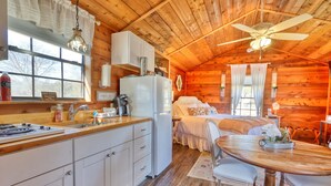 A cozy cabin with a kitchen, dining area, and a bedroom.