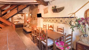 Zona de menjador rústica amb mobiliari de fusta, una banca de pedra i un frontal d'azulejos.