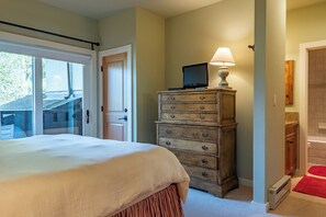 A bedroom with a bed, a dresser, a television on top of the dresser, and a door leading to a balcony. - Wildflower Condo 671 - Beautiful Sun Valley Resort Condo For 8 Guests (Sun Valley)