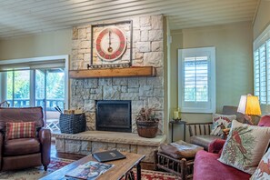 A cozy living room with a stone fireplace, leather furniture, and a large clock. - Wildflower Condo 671 - Beautiful Sun Valley Resort Condo For 8 Guests (Sun Valley)
