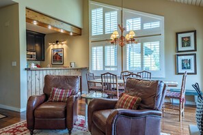 A spacious living room with leather armchairs, a dining table, and a kitchen in the background. - Wildflower Condo 671 - Beautiful Sun Valley Resort Condo For 8 Guests (Sun Valley)