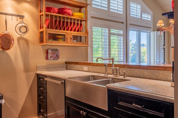 A kitchen with a stainless steel sink, wooden cabinets, and a window with blinds. - Wildflower Condo 671 - Beautiful Sun Valley Resort Condo For 8 Guests (Sun Valley)