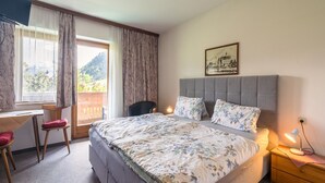 A bedroom with a bed, a desk, a chair, and a nightstand. - Apartment in Maishofen near Ski Slopes (Maishofen)