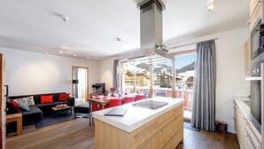 Una sala de estar moderna con suelo de madera, un sofá y un comedor con mesa y sillas.