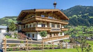 A multi-story wooden building with balconies, named "KINDLERHOF," surrounded by a wooden fence and set against a mountainous backdrop. - Farmhouse in Schwendau near Ski Zillertal (Mayrhofen - Schwendau)
