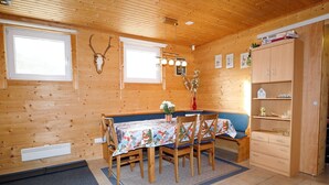 A wooden cabin interior with a dining table, chairs, a bench, a cabinet, and a wall-mounted deer skull. - Chalet in Ötztal near Ötz-Hochötz Ski Resort (Umhausen)