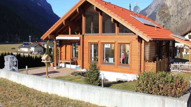 A wooden chalet with a red roof, large windows, and a patio area. - Chalet in Ötztal near Ötz-Hochötz Ski Resort (Umhausen)